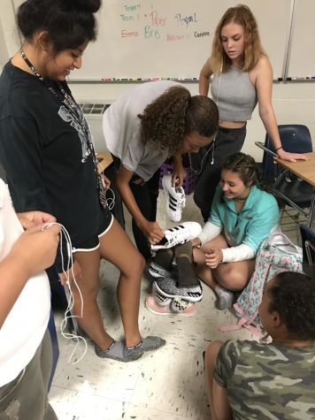 This staff works as a team to build a shoe tower during a team-building exercise.