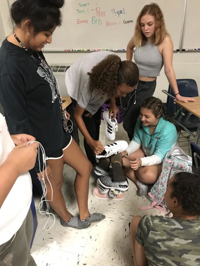 This staff works as a team to build a shoe tower during a team-building exercise.